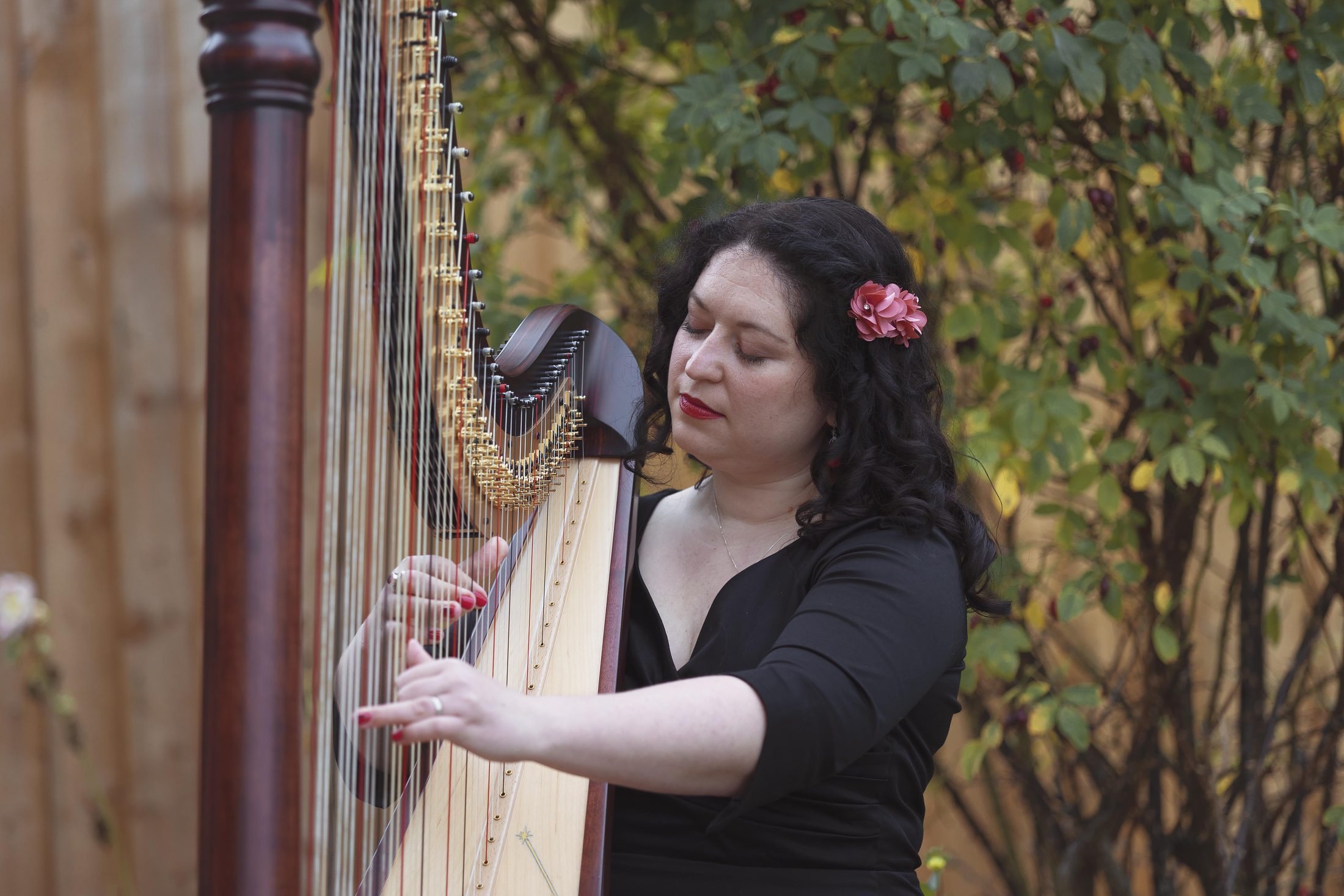 Maria playing harp in a calm outdoor setting